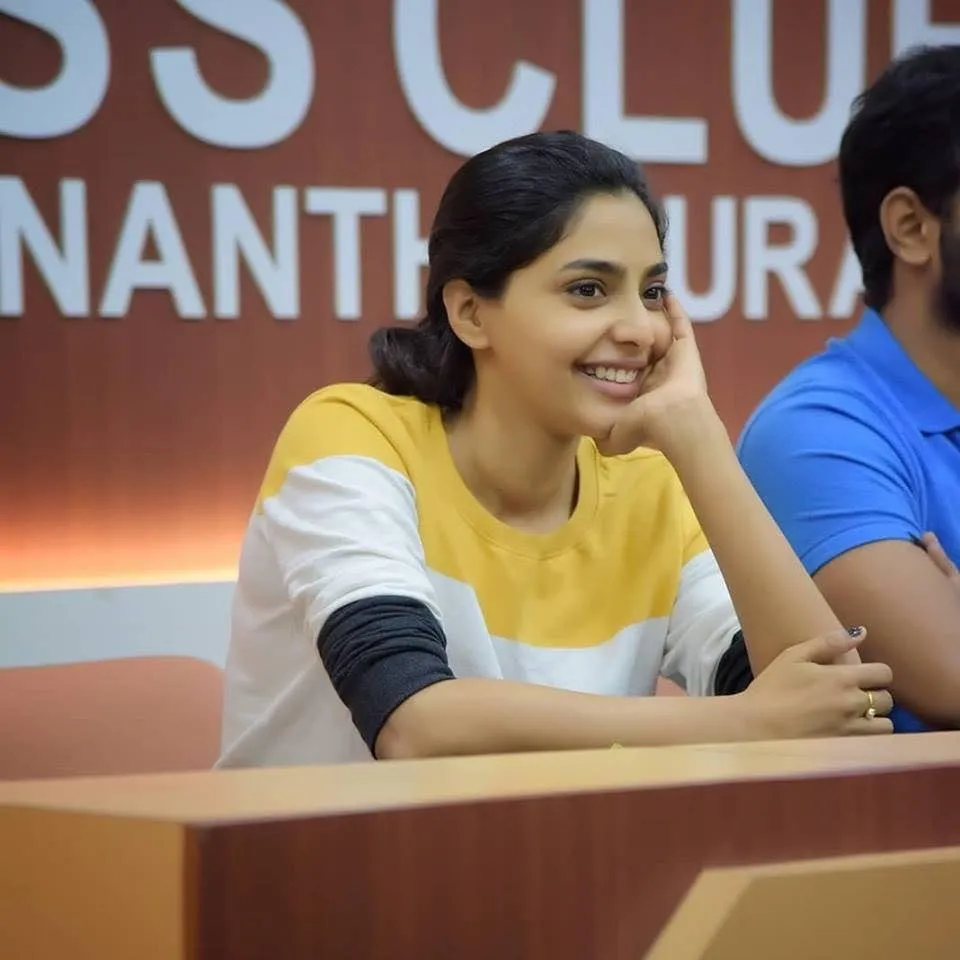 Aishwarya Lekshmi smiling at a press club appearance