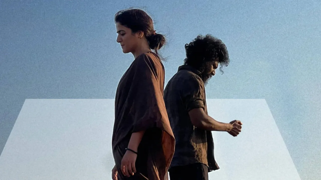Wamiqa Gabbi and Lokesh Kanagaraj standing back to back against an open sky in a still from DC