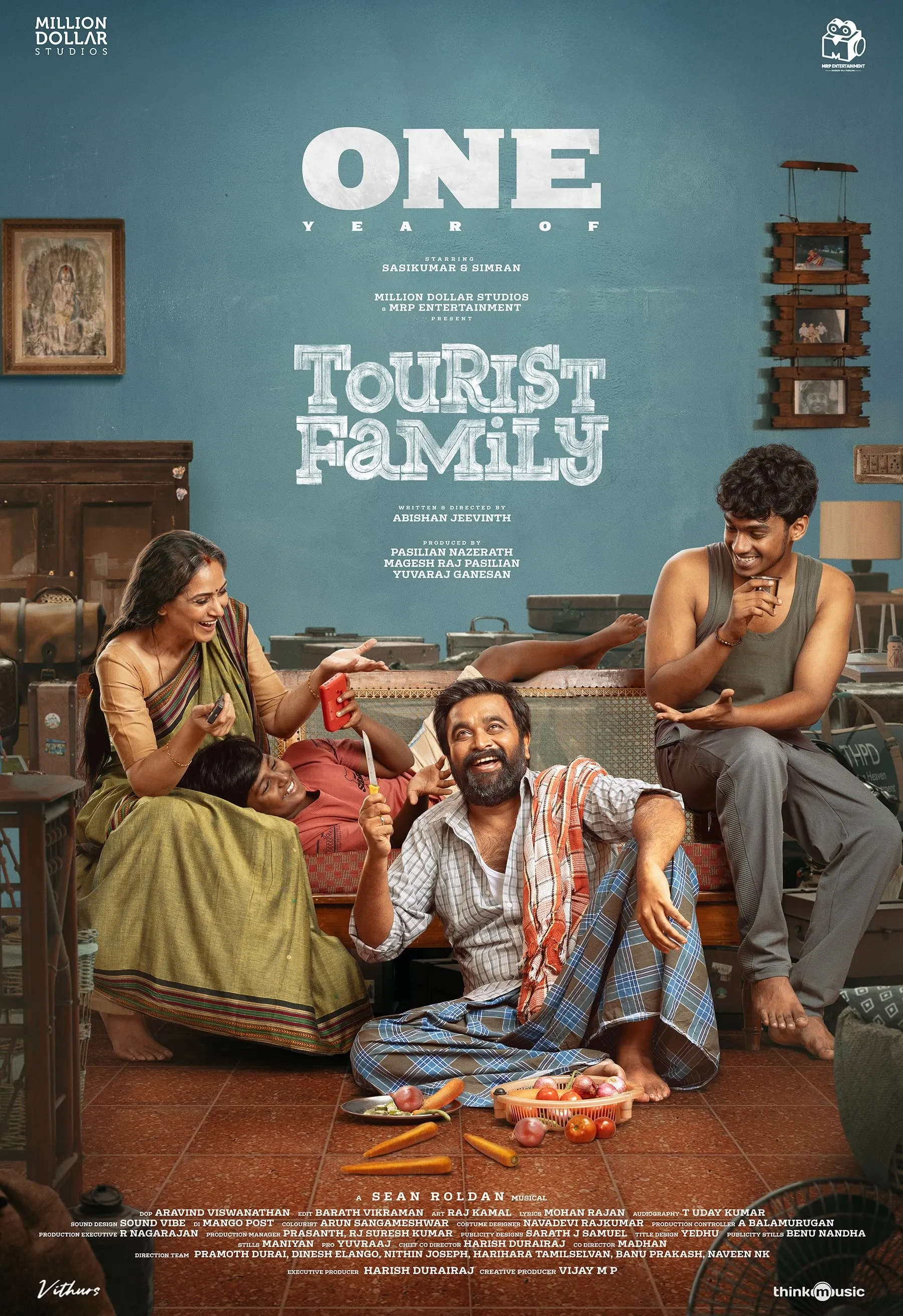 One Year of Tourist Family poster with Sasikumar, Simran and the family cast in a warmly lit living room