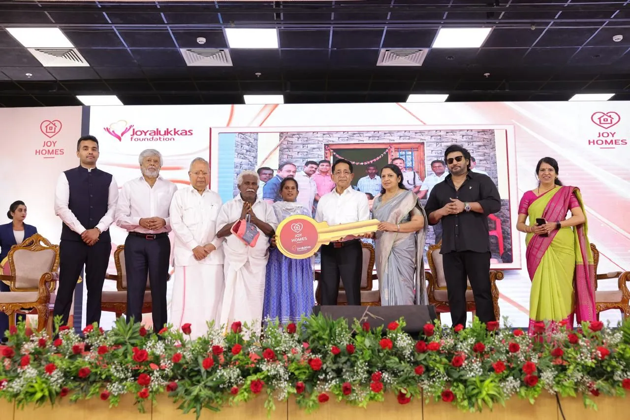 Joy Homes key handover ceremony with Prashanth and Joy Alukkas presenting a golden key to beneficiary families
