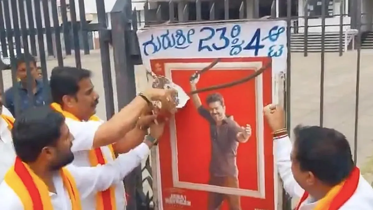 Members of a Kannada organisation tearing a Jana Nayagan poster off the gates of a theatre in Mandya