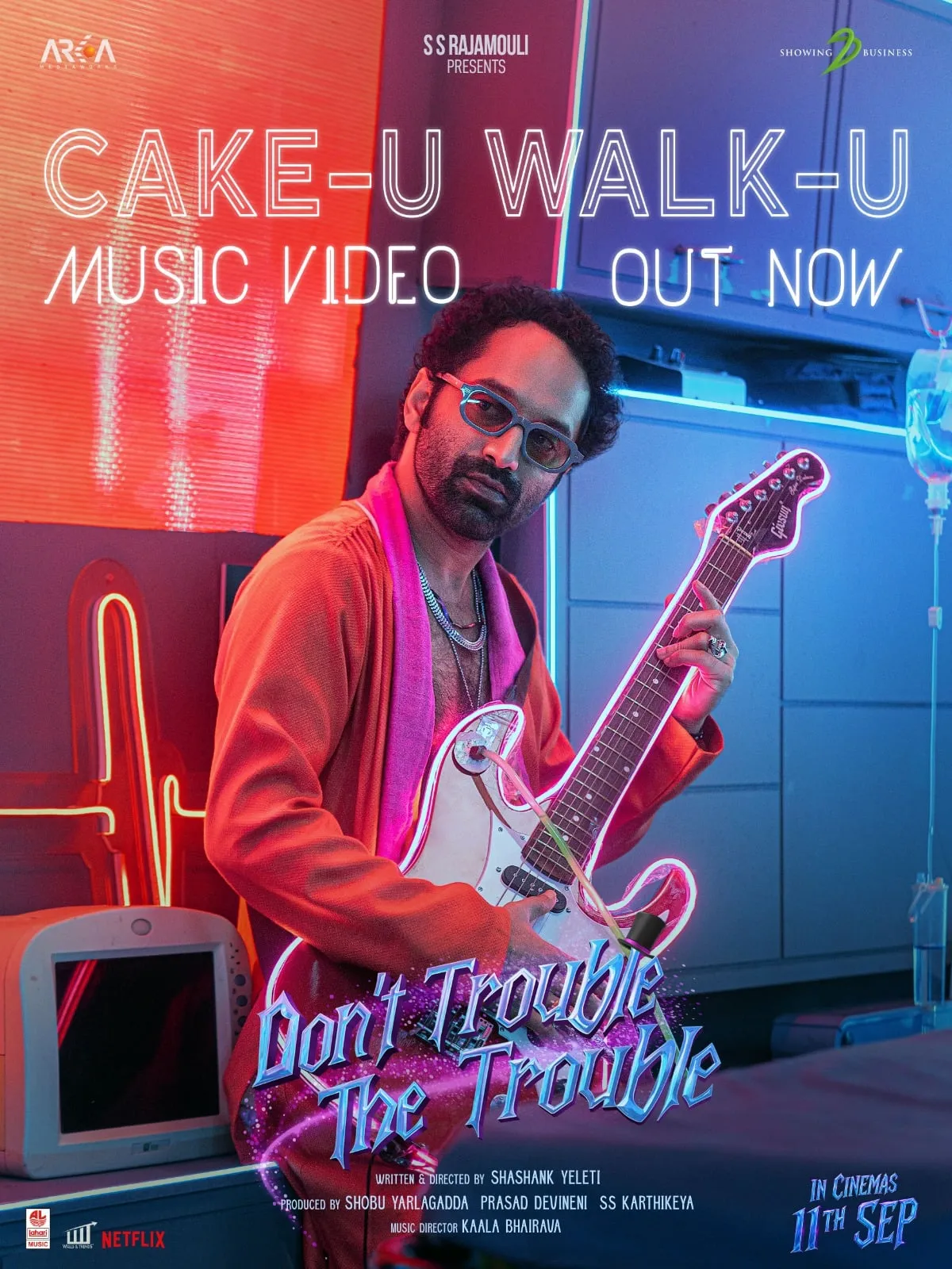 Fahadh Faasil in tinted glasses holding a neon-lit guitar on the Cake-u Walk-u poster