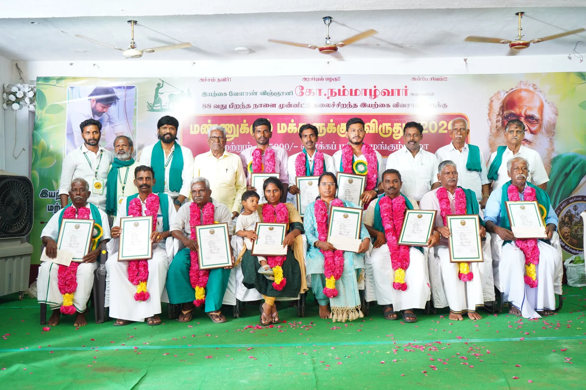 The eleven organic farmers honoured in Thanjavur, holding their certificates on stage