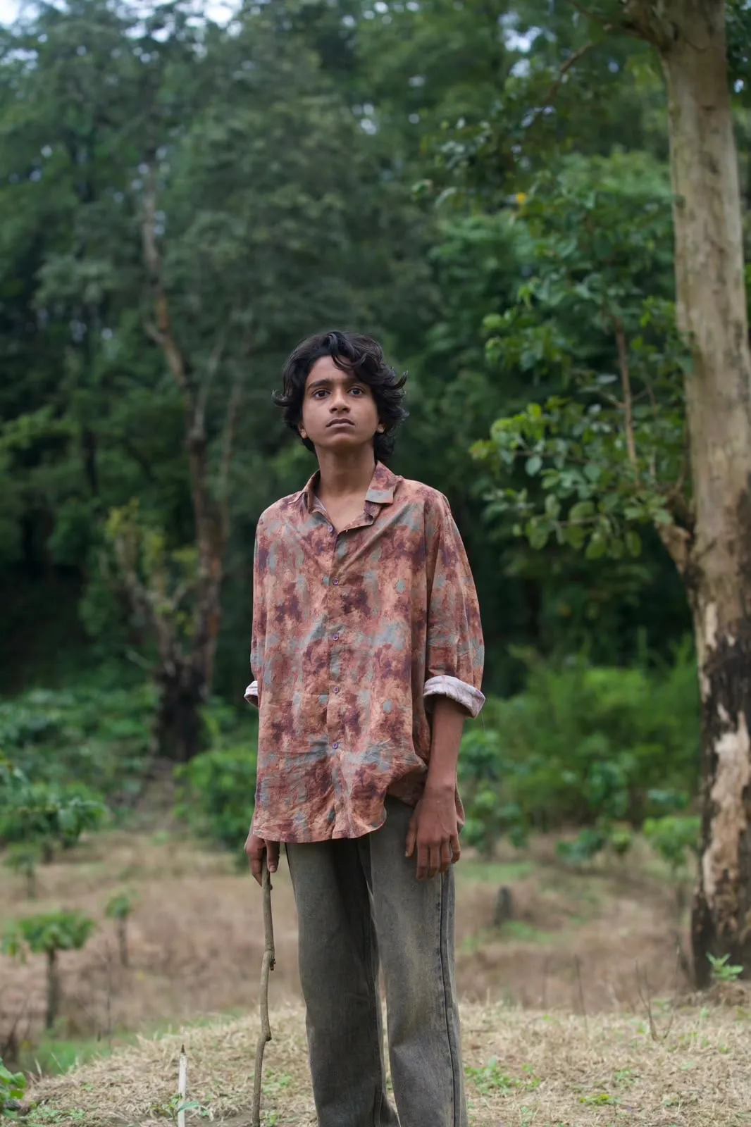 A still from Balan The Boy showing the young protagonist in a forest clearing