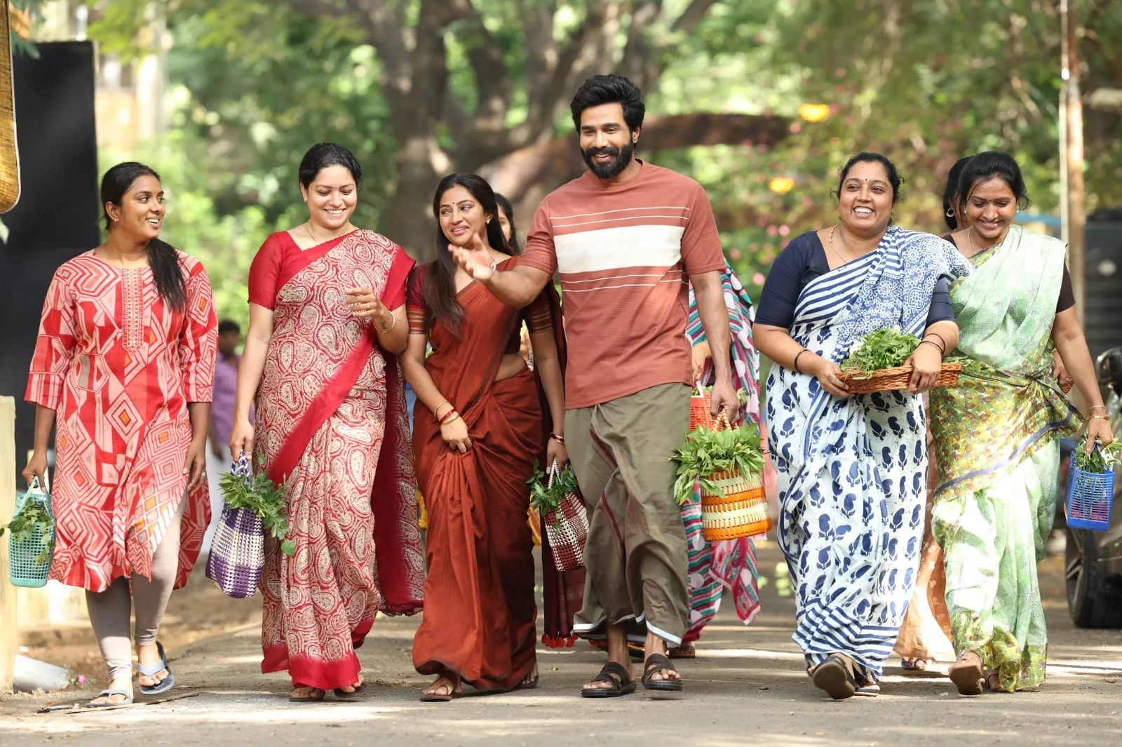 Vishnuu Vishal walks with a group of neighborhood women carrying vegetable baskets in Gatta Kusthi 2