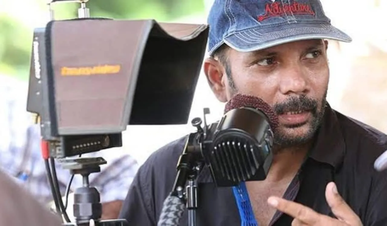 R. Chezhiyan at work on set beside a camera.