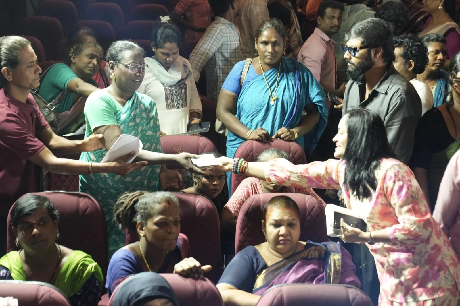 Cheques are handed out to members of the transgender community seated in the theatre