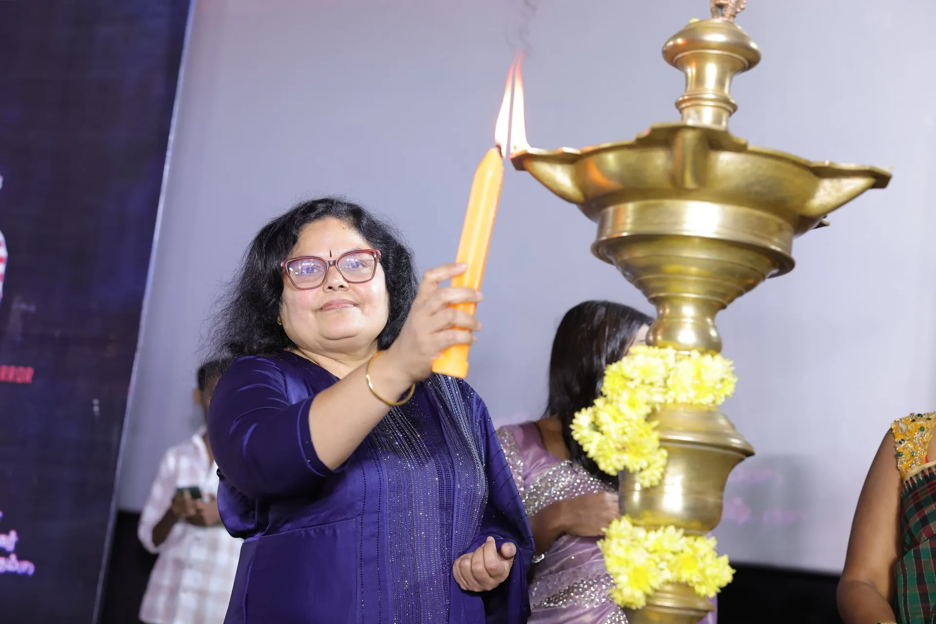 A guest lights the ceremonial lamp at the America Aavi launch